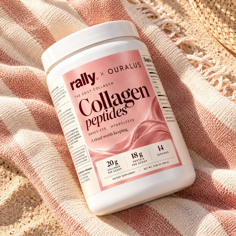The Daily Collagen tub lying on a pink striped towel in the sun
